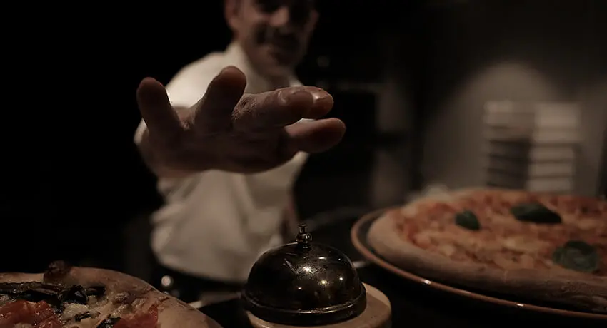 Chef at World of Riccardos in Halmstad rings the bell to tell us that pizzas are ready to serve.