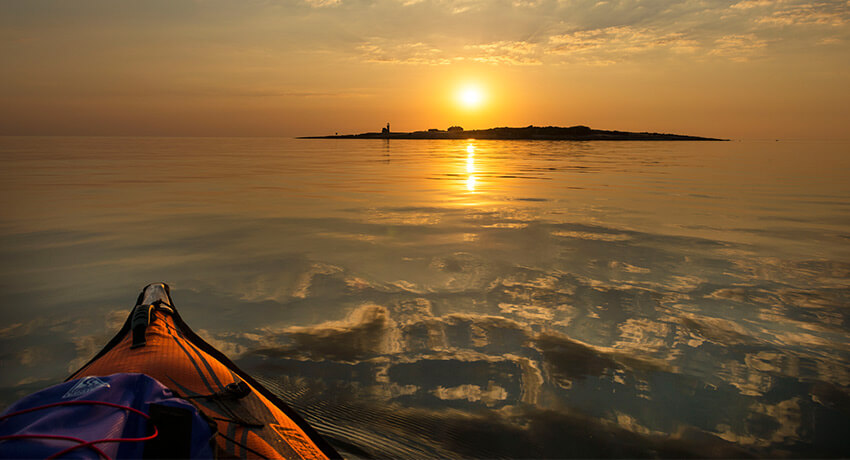 Framsidan på kanoten i bild och en solnedgång