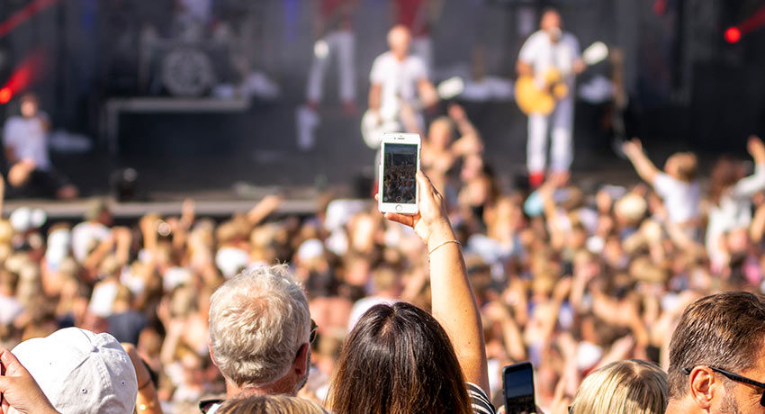 person fotograferar med sin mobil under en konsert på Solgården i Tylösand, Halmstad