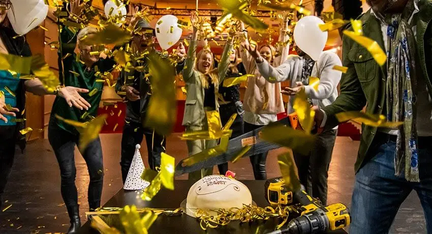 Flera personer firar med tårta och konfetti att Halmstads Teater renoverats och fyller 70 år