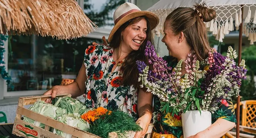 Två personer bär blommor och grönsaker i Halmstad