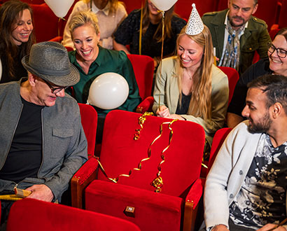Publik på Halmstads Teater tittar på en stol är ingen sitter.