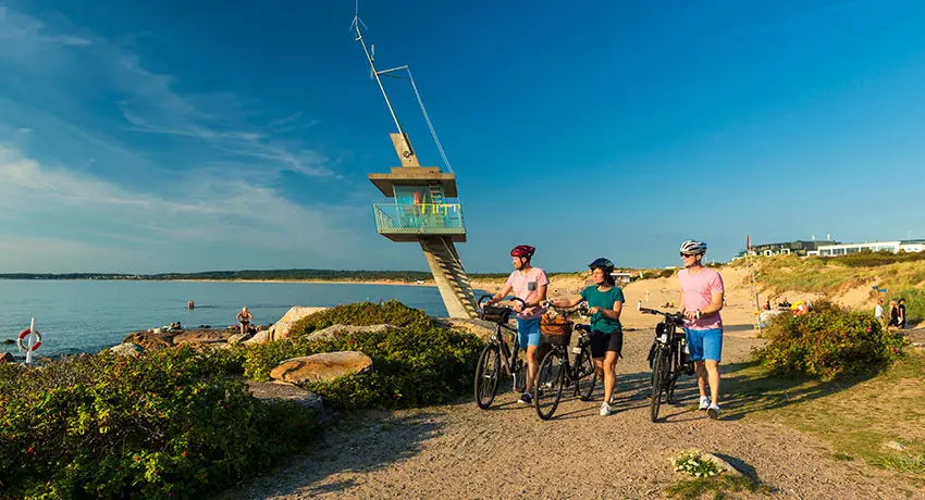 Cyklister går ved livreddertårnet i Tylösand